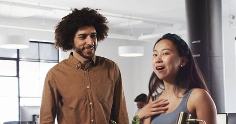 Diverse Colleagues Engaged in Fun Conversation at Modern Office