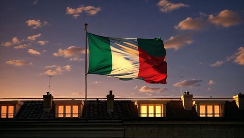 Italian flag waves at dusk over rooftop cityscape