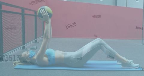 Masked Woman Exercising with Medicine Ball at Gym Post-COVID