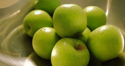 Vibrant Green Apples in Stainless Steel Bowl