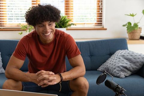 Podcaster in Home Studio Relaxing Behind Microphone