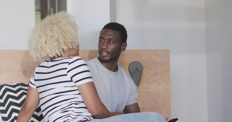 African american couple smiling together on bed, expressing joy and intimacy
