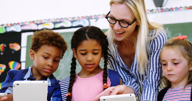 Teacher Guiding Young Students Using Digital Tablets in Classroom - Download Free Stock Images Pikwizard.com