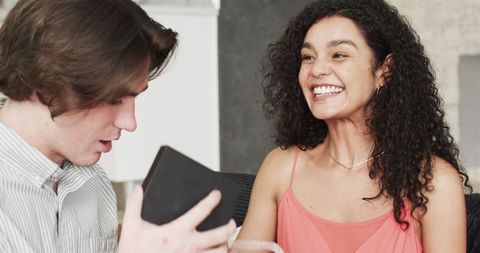 Joyful Couple Exchanging Anniversary Gifts in Living Room