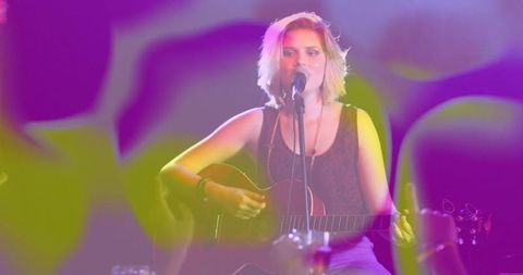 Singer with Acoustic Guitar Performing Live on Stage