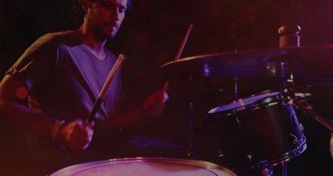 Male musician performing energetic drum solo on stage