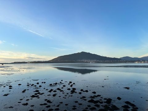 Serene coastal beach sunrise with distant hills