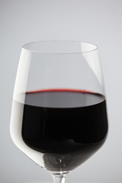 Glass of red wine against white background