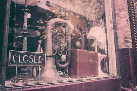 Vintage shop display with musical instrument including a tuba and closed sign