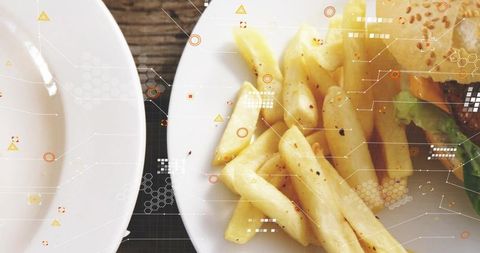 Closeup crispy fries and sesame burger on white plate with futuristic tech overlays