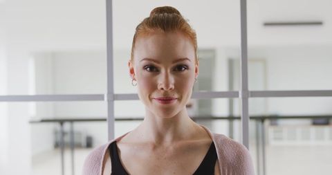 Joyful Ballet Dancer Smiling in Bright Dance Studio Setting