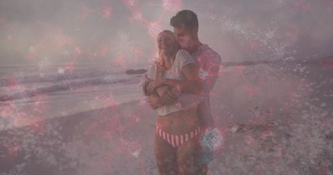 Couple Embracing on Beach at Dusk with Dreamy Pink Snowflake Overlay for Romantic Mood