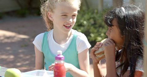 Happy Children Lunch Outdoors Sharing Joy and Food Together