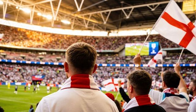 England football fans cheering at packed stadium waving st george cross flags