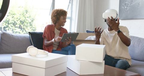 Couple testing virtual reality headset at home during gadget unboxing and demo