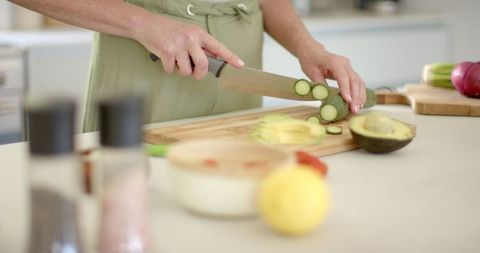 Woman Slicing Vegetables in Modern Kitchen Setting