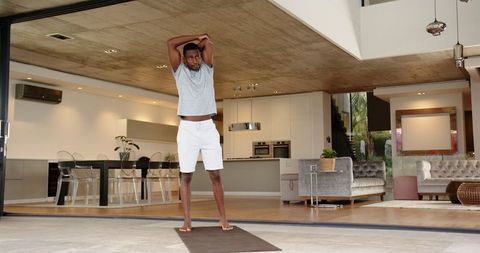Athlete Stretching on Yoga Mat in Modern Home Patio