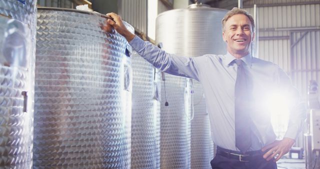 Businessman in Industral Setting Standing Near Large Steel Tanks - Download Free Stock Images Pikwizard.com