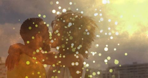 Romantic Couple Embracing on Scenic Rooftop at Sunset with Golden Bokeh
