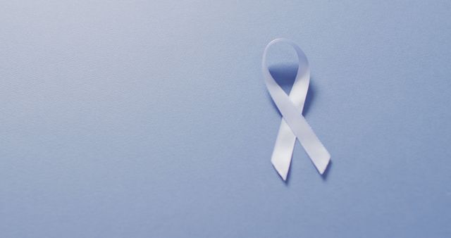 Image of pale blue prostate cancer ribbon on blue background. medical and healthcare awareness support campaign symbol for prostate cancer.
