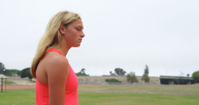 Serious Young Athlete Standing on Track Field in Red Tank Top - Download Free Stock Images Pikwizard.com