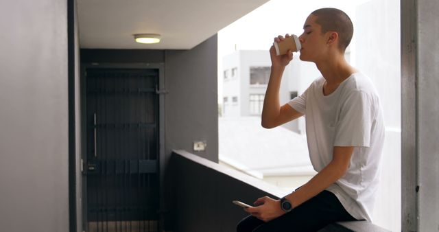 Relaxed Individual Sipping Coffee on Balcony with Minimalist Design - Download Free Stock Images Pikwizard.com