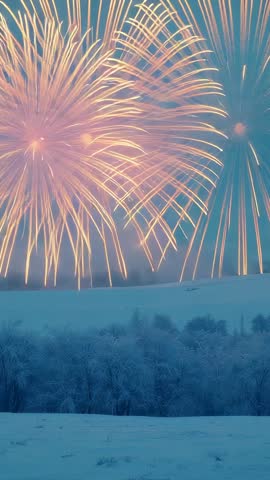 Vertical video showing gold fireworks bursting over snowfield, frosted trees, smoky trails