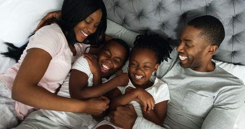 Happy African American Family Enjoying Playful Moments in Bed