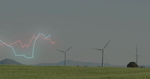 Wind turbines turning over green field with renewable energy market chart overlay