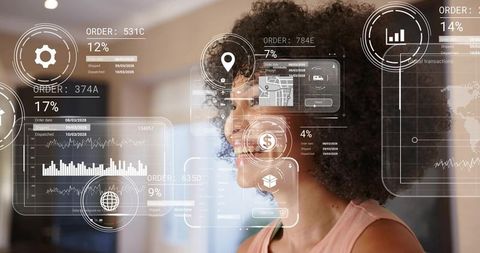 Smiling woman analyzing augmented reality dashboards and order tracking HUD in office