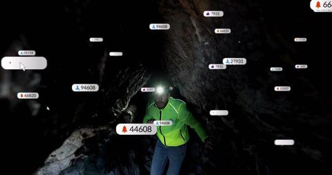 Man exploring dark rocky cave with digital notification overlays