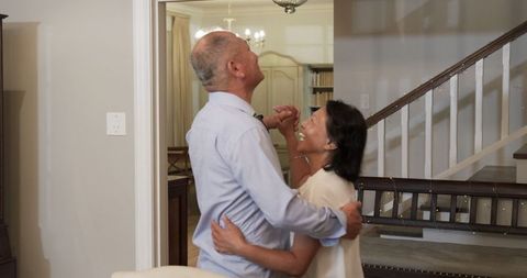 Elderly couple smiling and celebrating at home with affection
