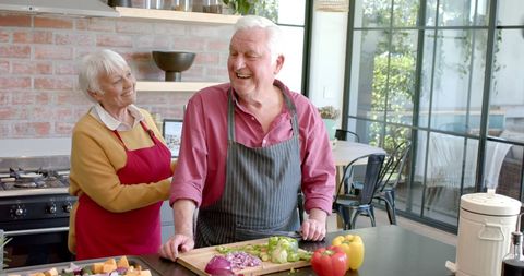 Senior Couple Cooking and Sharing Joyful Moments in Home Kitchen