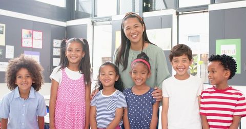 Diverse Group of Elementary Students with Smiling Teacher in Classroom
