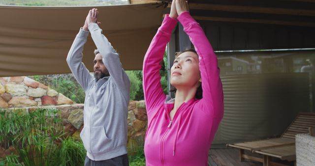 Happy diverse couple doing yoga, standing and meditating at terrace - Download Free Stock Photos Pikwizard.com