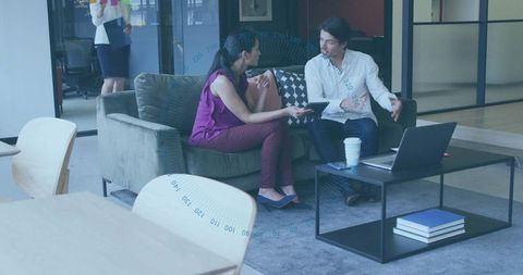 Colleagues discussing project in modern office lounge