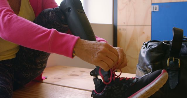 Person with Prosthetic Leg Tying Shoelaces on Sports Shoe in Locker Room - Download Free Stock Images Pikwizard.com