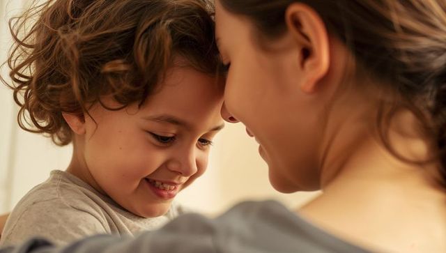 Parent cuddling smiling curly-haired child sharing warm intimate home moment of affection