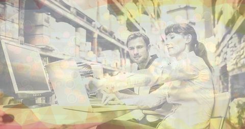 Warehouse team collaborating on laptop amid digital overlay