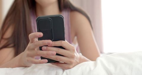 Teen Girl Browsing on Smartphone Relaxed in Cozy Bedroom