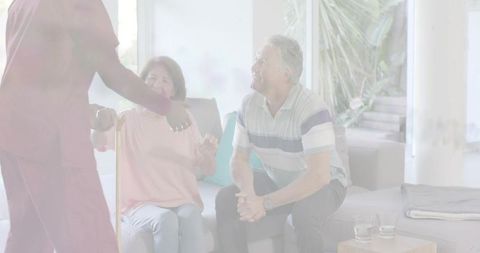 Compassionate caregiver reaching to assist senior woman with cane on living room sofa