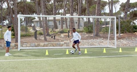 Kids practice dribbling skills in outdoor soccer training