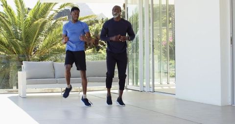 Father and Son Enjoy Outdoor Cardio Together on Modern Patio