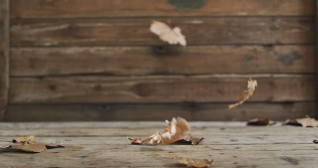 Falling autumn leaves against rustic wooden background, perfect for nature-inspired themes. Ideal for use in seasonal promotions, blog posts, and wallpaper designs, highlighting the beauty of fall.