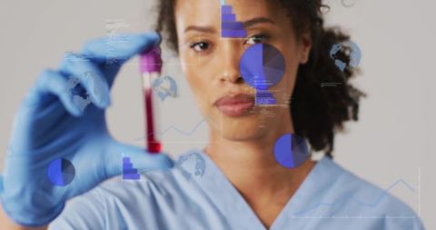 Female lab technician analyzing blood vial with data overlay for healthcare analytics