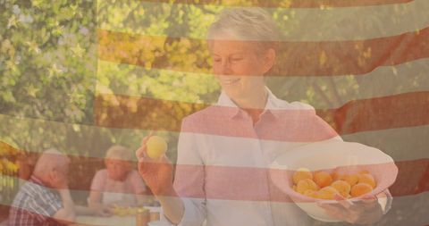 Senior friends dining outdoors with usa flag overlay