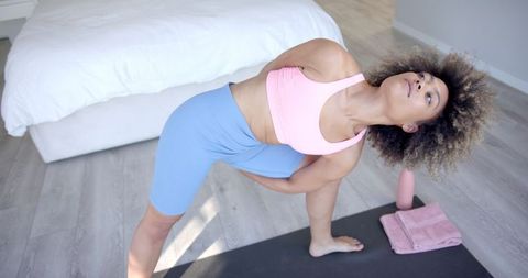 Woman Practicing Yoga at Home in Bright Bedroom