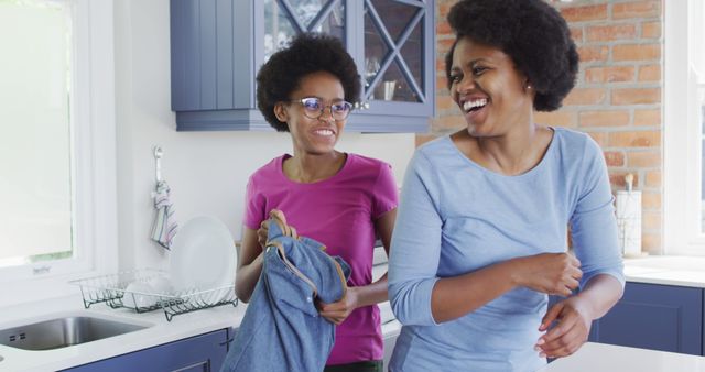 Mother and Daughter Smiling and Washing Dishes in Kitchen - Download Free Stock Images Pikwizard.com