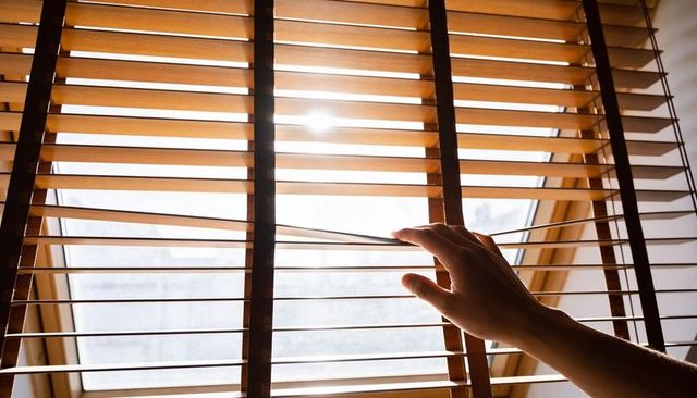 Hand Opening Wooden Venetian Blinds at Skylight Window, Warm Sun Glare and Morning Light