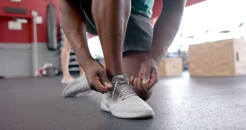 Man Tying Sneakers in Gym Ready for Workout
